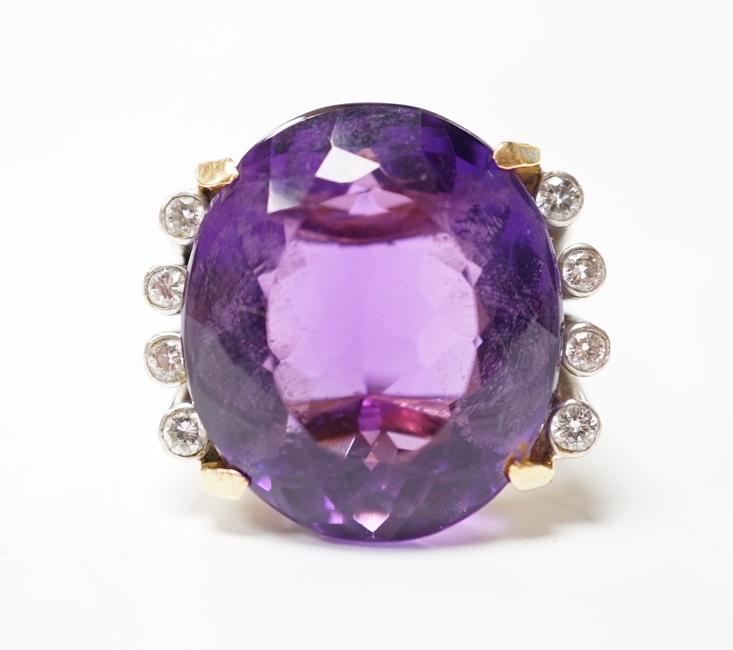 A large yellow and white metal and single stone oval cut amethyst set dress ring, flanked by eight small round cut diamonds, size K, gross weight 15.3 grams.